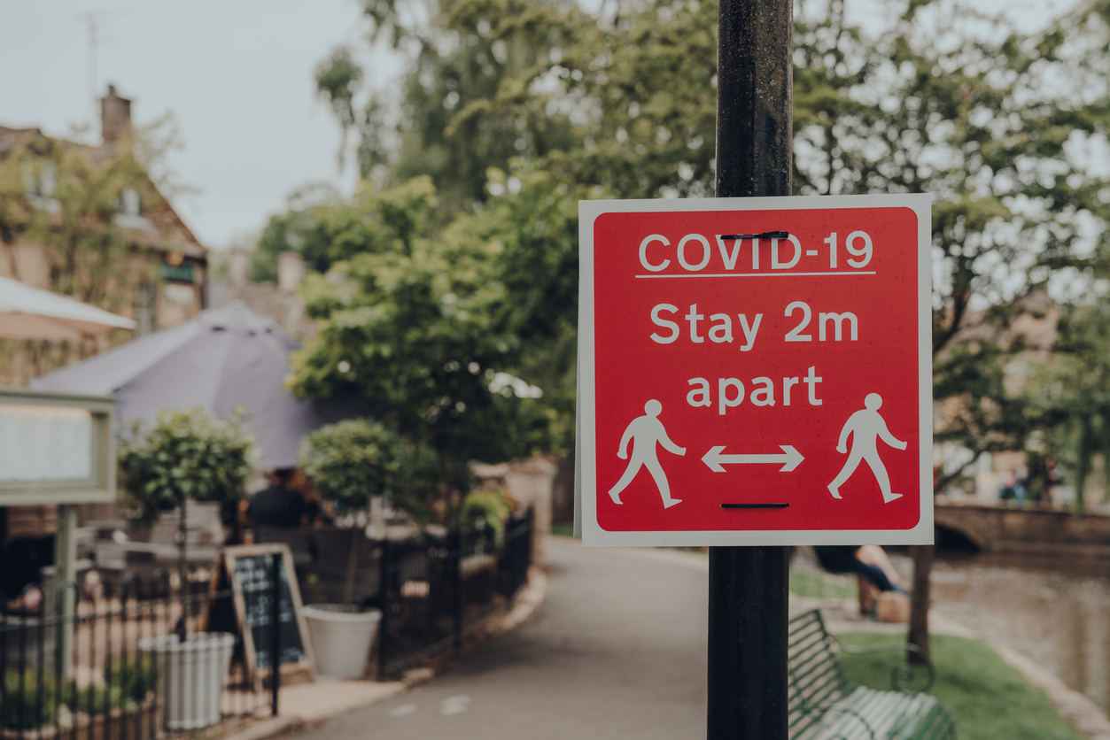 Sign reading "Covid-19: stay 2m apart" - One year on from