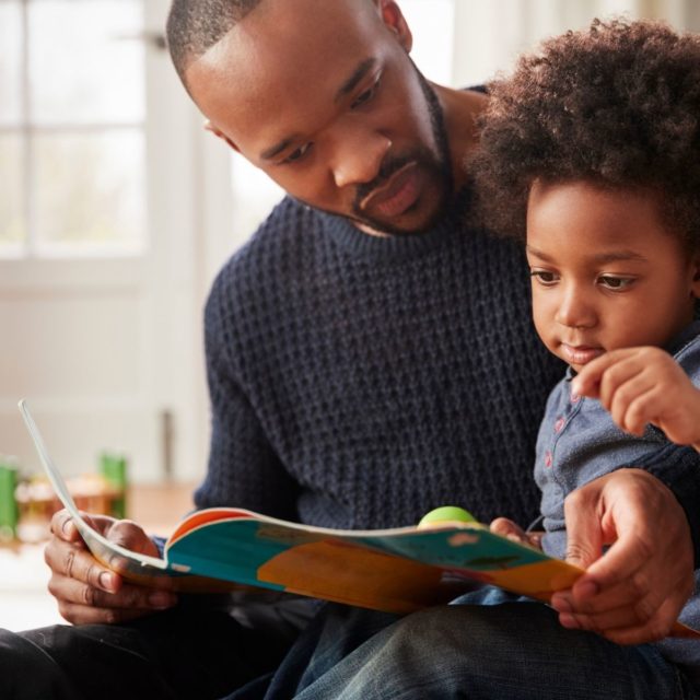 A father reading to his young son, Covid-19 and the Impact