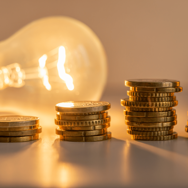 Light bulb and increasing stack of coins