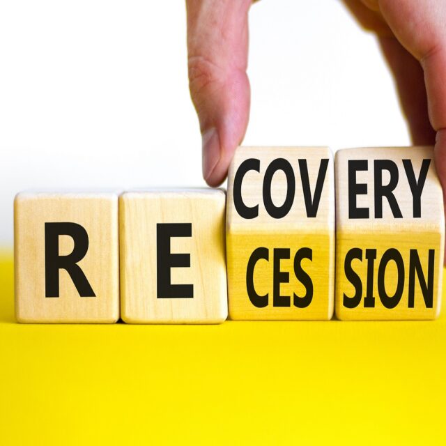 Recovery and recession symbol. Businessman hand turns cubes and changes the word 'recession' to 'recovery'. Beautiful white background. Business and recovery - recession concept.